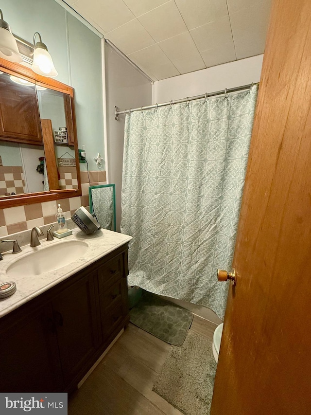 full bath with tasteful backsplash, toilet, vanity, and wood finished floors