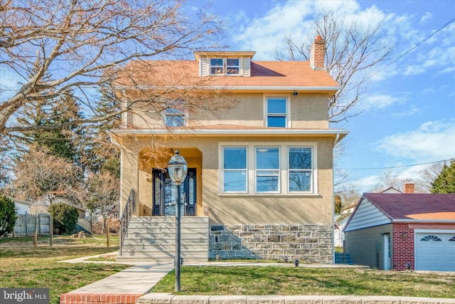 american foursquare style home with stone siding, a front lawn, a chimney, and stucco siding