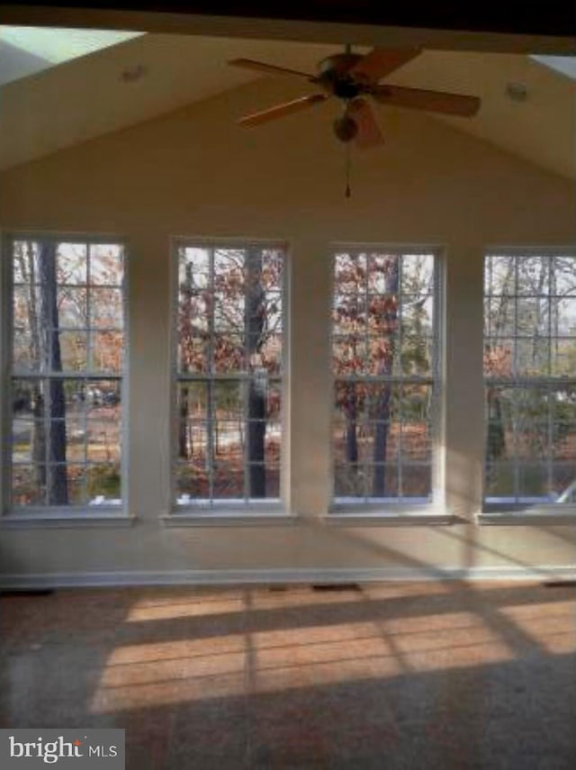 unfurnished sunroom with a ceiling fan, lofted ceiling, and a healthy amount of sunlight