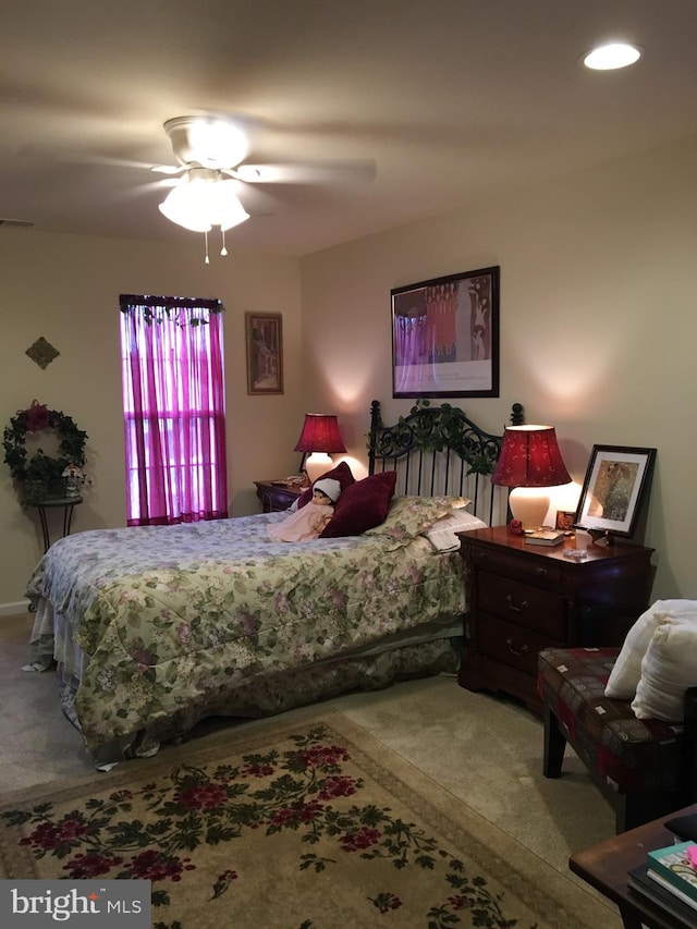 carpeted bedroom featuring a ceiling fan and visible vents