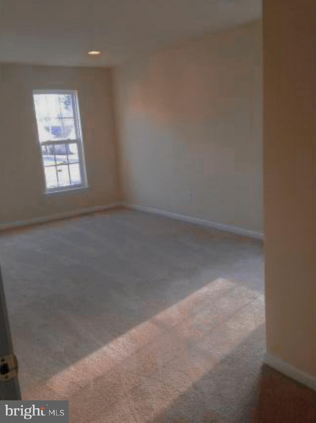 carpeted spare room with baseboards