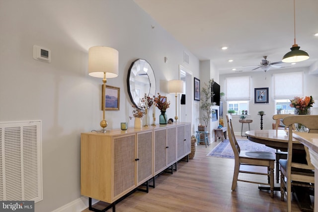 dining area with a ceiling fan, visible vents, baseboards, and wood finished floors