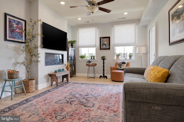 living room with baseboards, visible vents, and light wood-style floors