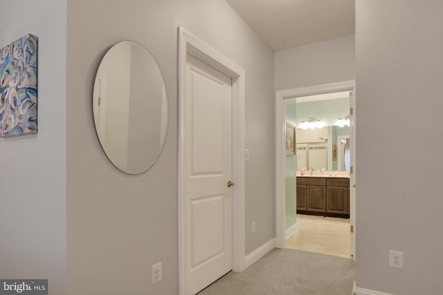 hallway with light carpet and baseboards