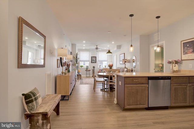 kitchen featuring pendant lighting, light countertops, visible vents, stainless steel dishwasher, and light wood-style floors