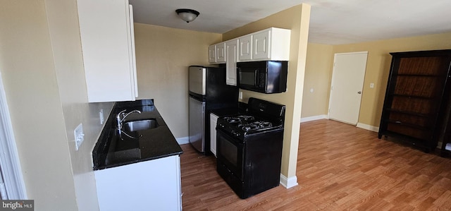 kitchen with light wood-style flooring, a sink, baseboards, white cabinets, and black appliances