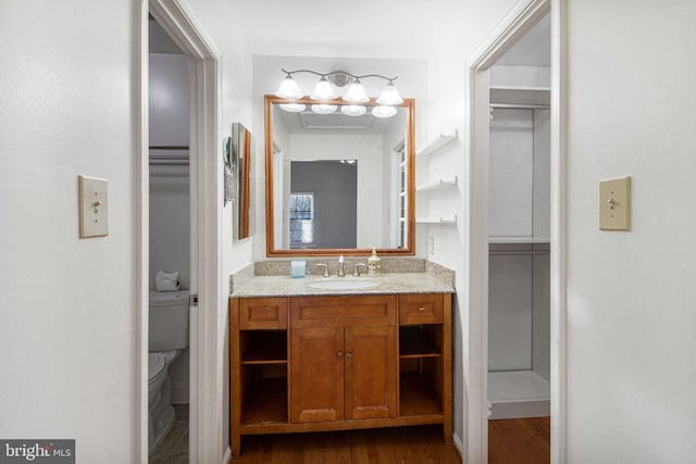 bathroom with vanity, toilet, and wood finished floors