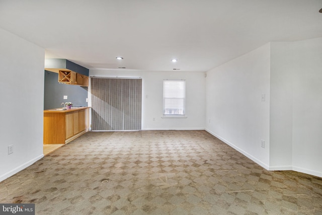 unfurnished living room featuring recessed lighting, carpet flooring, and baseboards