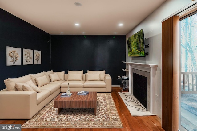 living room with a fireplace, wood finished floors, and recessed lighting