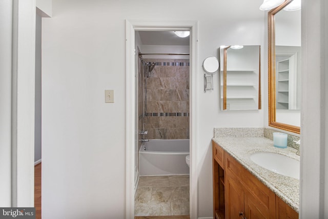 bathroom featuring toilet, vanity, and shower / tub combination