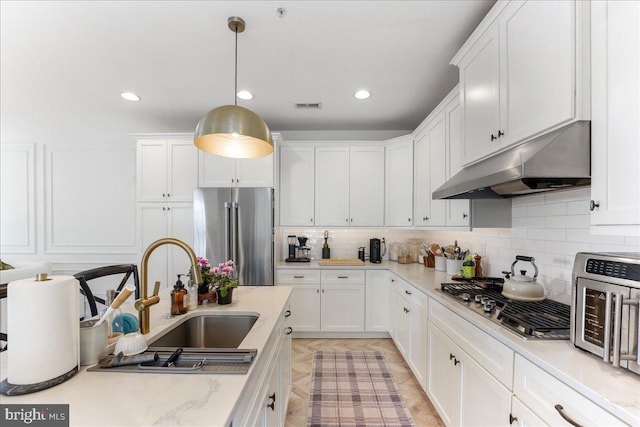 kitchen with visible vents, stainless steel appliances, under cabinet range hood, white cabinetry, and a sink