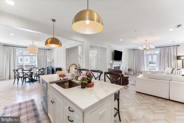 kitchen with a breakfast bar, a wealth of natural light, a sink, and stainless steel dishwasher