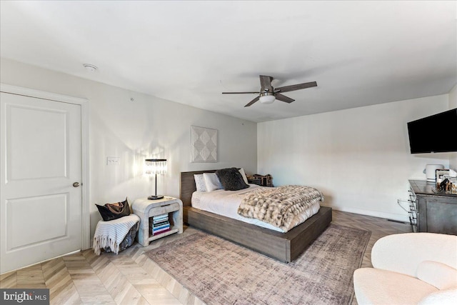 bedroom with a ceiling fan and baseboards