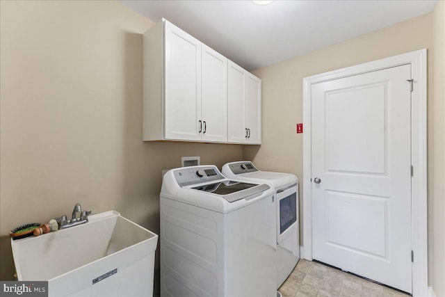 laundry room featuring washing machine and clothes dryer, a sink, and cabinet space