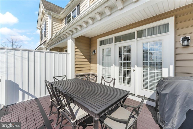 wooden terrace with grilling area and outdoor dining area