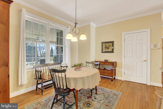 dining room with light wood-style floors, a notable chandelier, ornamental molding, and baseboards