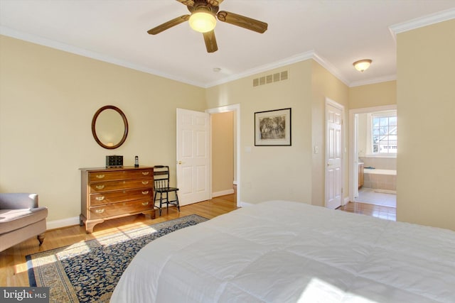 bedroom featuring visible vents, ornamental molding, connected bathroom, wood finished floors, and baseboards