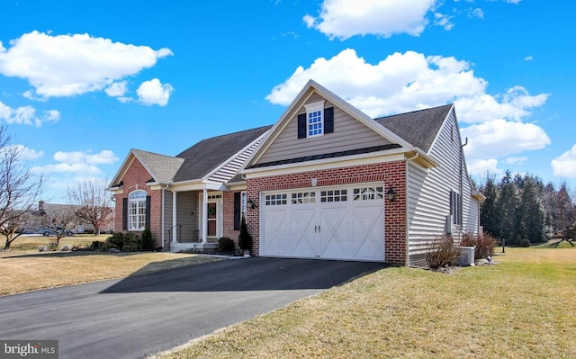 view of front of home with driveway, brick siding, a front lawn, and a shingled roof