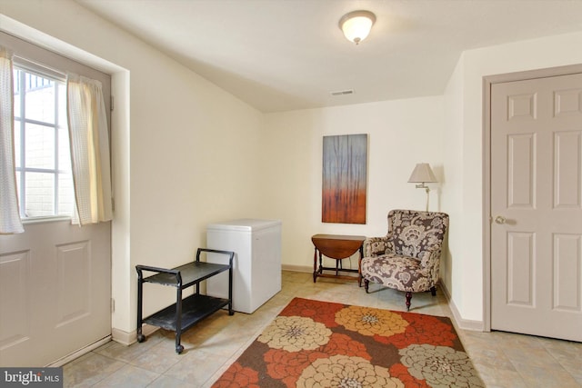 sitting room with light tile patterned floors, visible vents, and baseboards