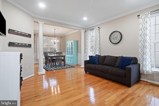 living area with light wood-style flooring, decorative columns, visible vents, and ornamental molding