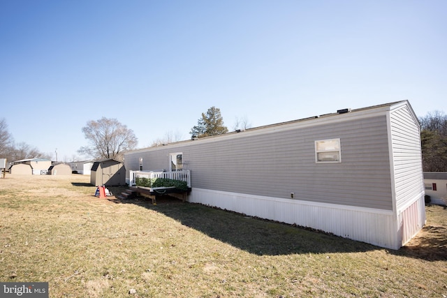 view of home's exterior featuring a shed, a lawn, and an outdoor structure