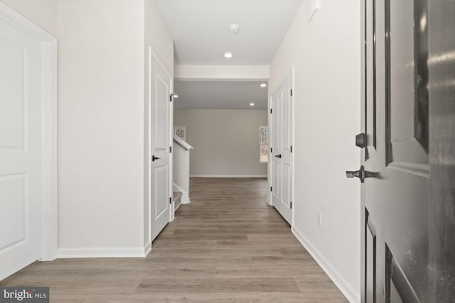 hall featuring recessed lighting, light wood-type flooring, and baseboards