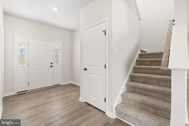 foyer entrance with recessed lighting, visible vents, wood finished floors, baseboards, and stairs