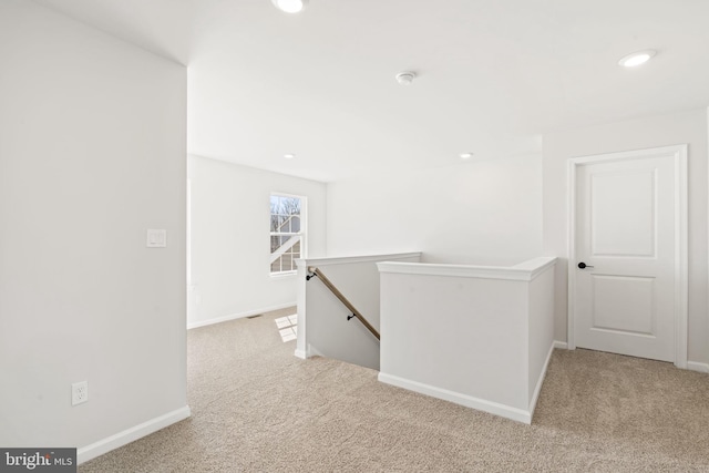 corridor with baseboards, recessed lighting, an upstairs landing, and light colored carpet