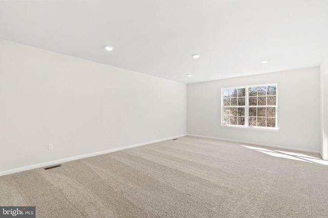 carpeted empty room featuring recessed lighting, visible vents, and baseboards