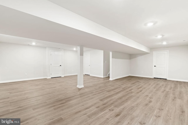 finished basement featuring light wood-style floors, recessed lighting, and baseboards