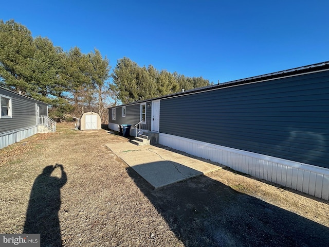 view of yard with entry steps, a storage shed, and an outbuilding