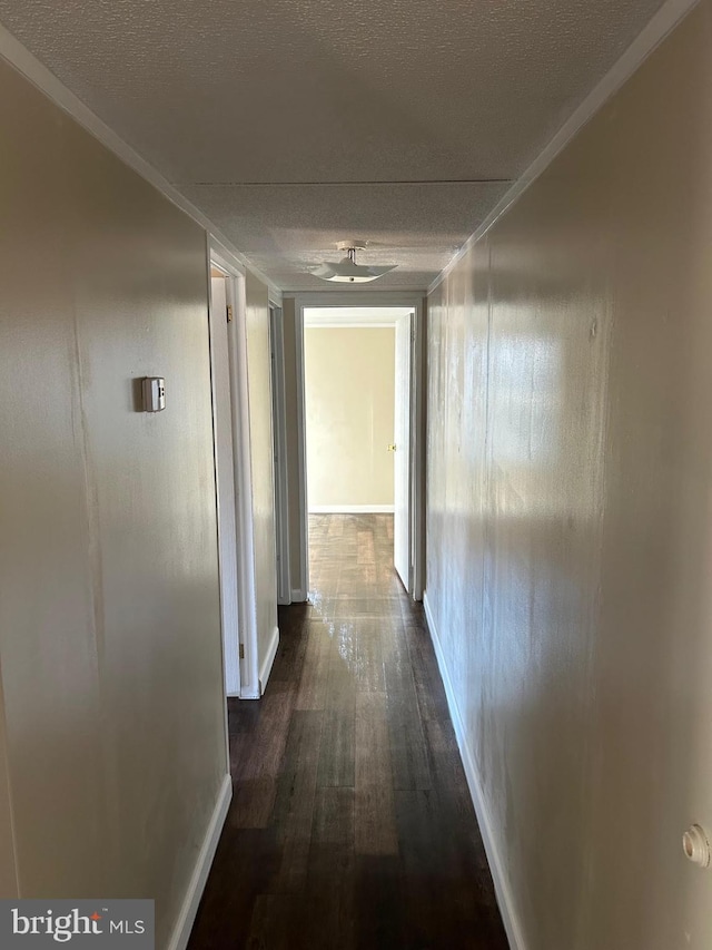 hall featuring dark wood-style flooring and a textured ceiling