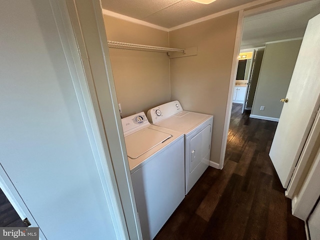 washroom featuring dark wood-style floors, laundry area, washing machine and clothes dryer, and baseboards