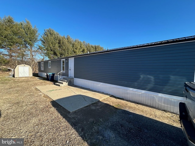 view of side of property with entry steps, a storage shed, and an outdoor structure