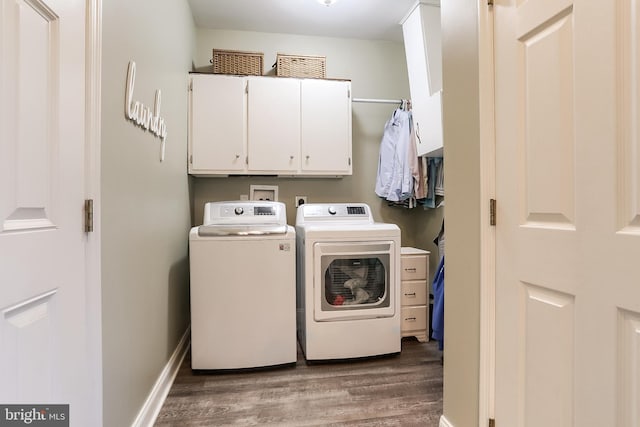 laundry area with cabinet space, baseboards, wood finished floors, and independent washer and dryer