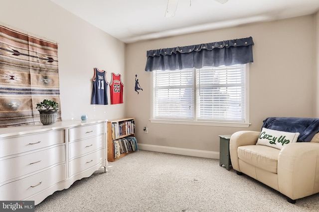 living area with light carpet and baseboards