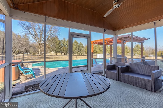 sunroom featuring lofted ceiling, ceiling fan, and wooden ceiling