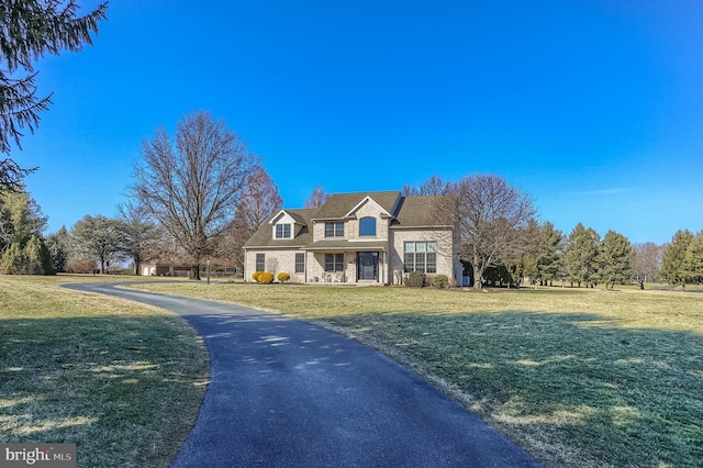 view of front of property with stone siding and a front lawn