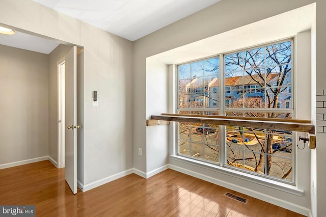 interior space featuring wood finished floors, visible vents, and baseboards