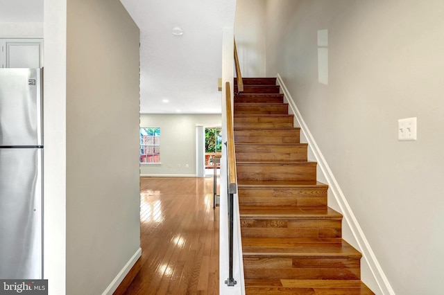 stairs with baseboards and hardwood / wood-style flooring