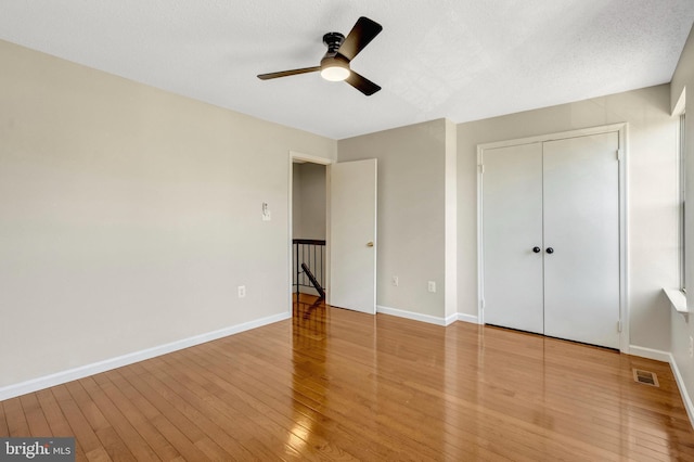 unfurnished bedroom featuring wood-type flooring, visible vents, and baseboards