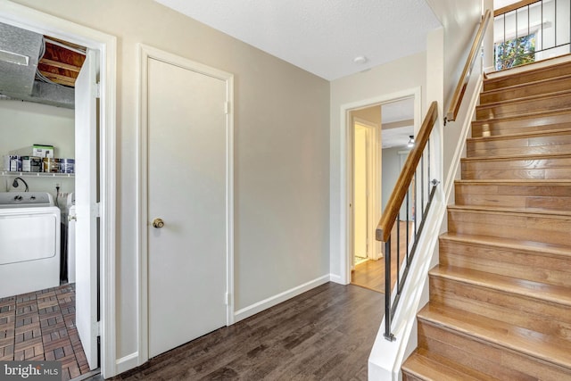 staircase with a textured ceiling, baseboards, wood finished floors, and independent washer and dryer