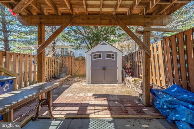 view of patio with a storage shed, a fenced backyard, a gate, and an outdoor structure