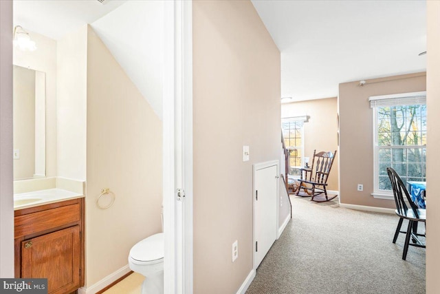 bathroom featuring baseboards, toilet, and vanity