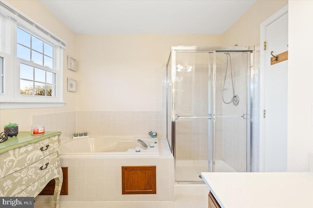 bathroom featuring a garden tub, vanity, and a shower stall