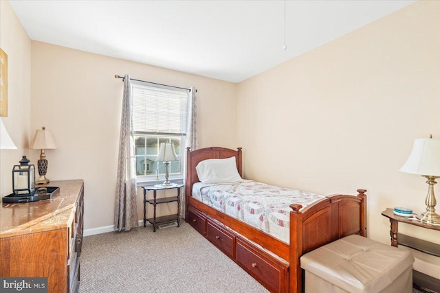 bedroom featuring light colored carpet and baseboards