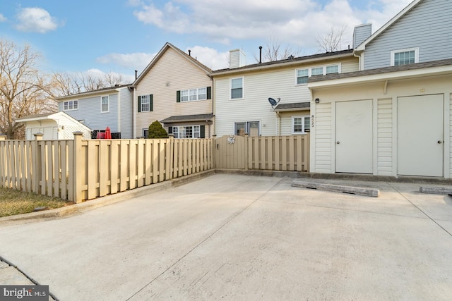 rear view of property with fence and a patio area