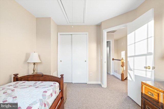 bedroom featuring attic access, baseboards, a closet, and light carpet