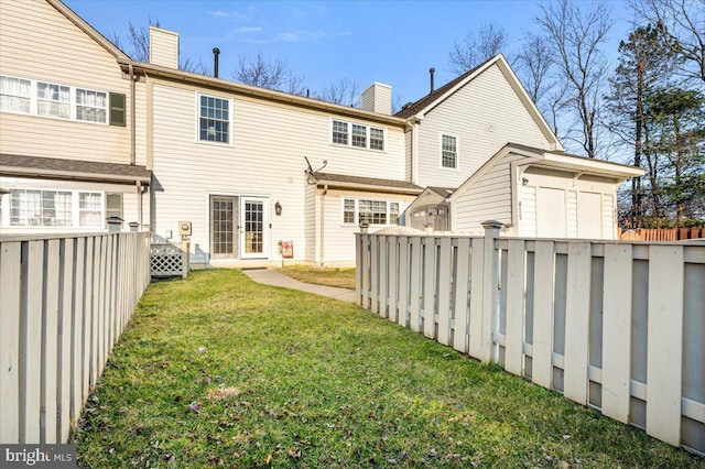 back of house with a yard and fence