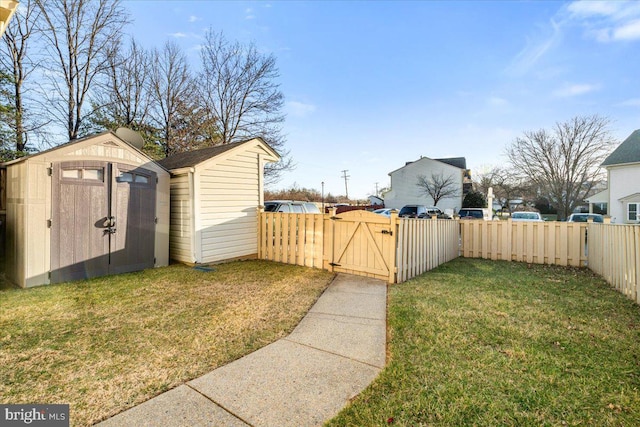 view of yard with a storage unit, an outdoor structure, fence private yard, and a gate